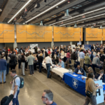 business owners attend the Reverse Vendor Trade Show inside the Fisher Pavilion at Seattle Center. Business owners speak with vendors at tables.